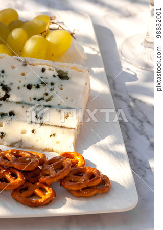 Roquefort cheese served with green grapes and snacks outdoors 98882001