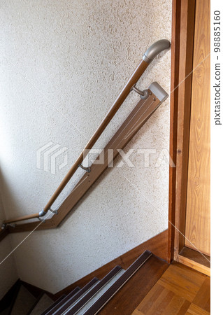 Stairs in an old detached house with handrails installed due to aging residents Stairs in an old detached house with handrails installed due to aging residents 98885160