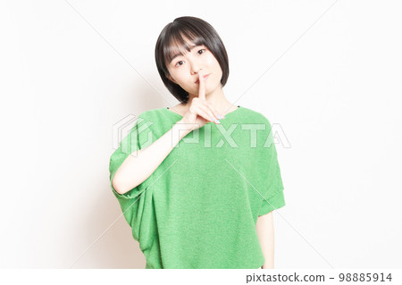 A young woman who hides her mouth with her hand and makes a secret pose 98885914