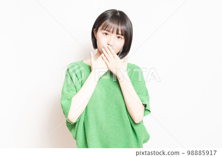 A young woman who hides her mouth with her hand and makes a secret pose 98885917
