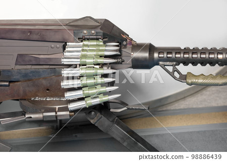 The tape with cartridges is loaded into a large-caliber machine gun. The tape with cartridges is loaded into a large-caliber machine gun. 98886439