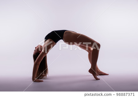 Portrait of beautiful young woman wearing black sportswear working out in studio. Full length. Portrait of beautiful young woman wearing black sportswear working out in studio. Full length. 98887371