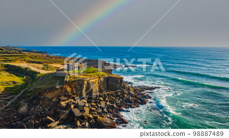 Scenic ocean landscape on summer rainy day. Beautiful rocky coast with cloudy sky. Portugal. Europe. Beautiful natural landscape with ocean rocky shore with rainy clouds and rainbow. Scenic ocean landscape on summer rainy day. Beautiful rocky coast with cloudy sky. Portugal. Europe. Beautiful natural landscape with ocean rocky shore with rainy clouds and rainbow. 98887489
