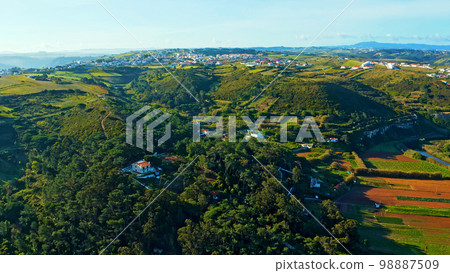 Top view of a European town with beautiful green landscape during sunset. Drone view of a beautiful small European city with a beautiful hilly landscape while sunset.  Portugal. 98887509