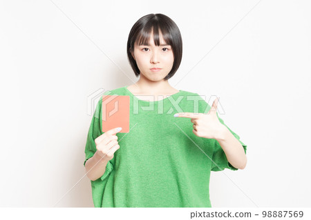 Young woman showing a red card Young woman showing a red card 98887569