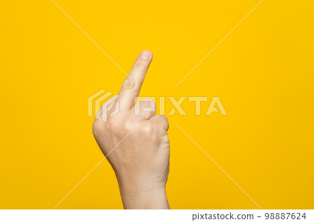 Finger hand symbols concept isolated sign of the middle finger in a gesture meaning fuck you or fuck off on yellow background. Finger hand symbols concept isolated sign of the middle finger in a gesture meaning fuck you or fuck off on yellow background. 98887624