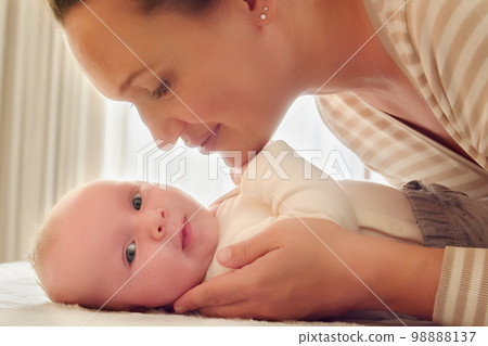 Young Mother looks in her newborn baby. Closeup portrait of a loving mother's kiss. Happy mom looking beautiful infant son. Mum loves of her infant child. Parenthood concept. Happy mom, happy kid. Young Mother looks in her newborn baby. Closeup portrait of a loving mother's kiss. Happy mom looking beautiful infant son. Mum loves of her infant child. Parenthood concept. Happy mom, happy kid. 98888137