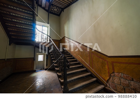 Interior of entrance hall with carved staircase 98888410