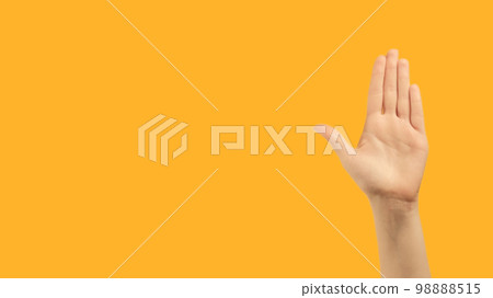 Stop gesture. No sign. Restriction rejection. Raised female hand palm warning with nope enough signal on orange copy space background. 98888515