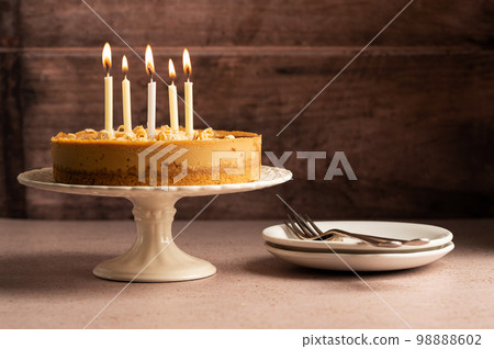 Birthday cake with burning candles, rustic wooden background, copy space. 98888602