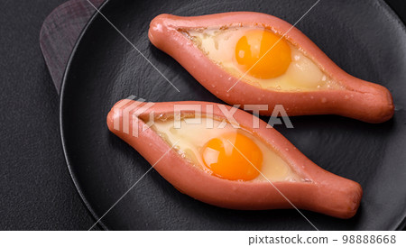 Composite concept of fried eggs inside a cut sausage with spices Composite concept of fried eggs inside a cut sausage with spices 98888668