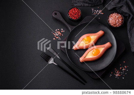 Composite concept of fried eggs inside a cut sausage with spices 98888674