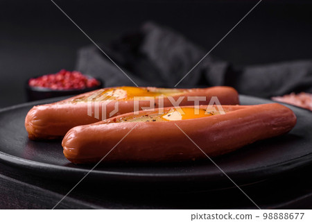 Composite concept of fried eggs inside a cut sausage with spices Composite concept of fried eggs inside a cut sausage with spices 98888677