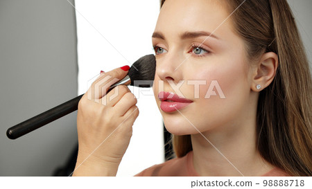 Makeup artist or stylist applies eyeshadow powder or shadows to the eyelids of the female model. Master class on applying makeup on the eyes. Beautiful woman face. Beauty fashion. Professional makeup. Makeup artist or stylist applies eyeshadow powder or shadows to the eyelids of the female model. Master class on applying makeup on the eyes. Beautiful woman face. Beauty fashion. Professional makeup. 98888718
