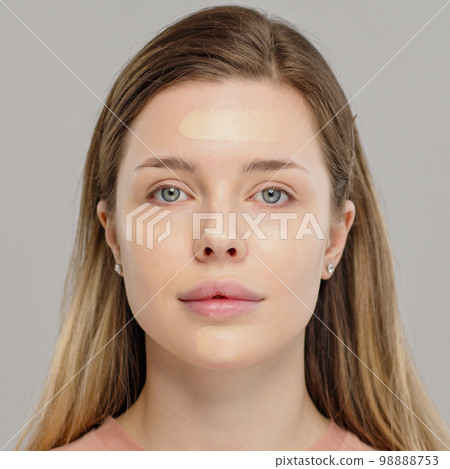 Foundation on the face of a female model. Cosmetic concealer base on a face. Professional makeup. Tutorial makeup master class Foundation on the face of a female model. Cosmetic concealer base on a face. Professional makeup. Tutorial makeup master class 98888753