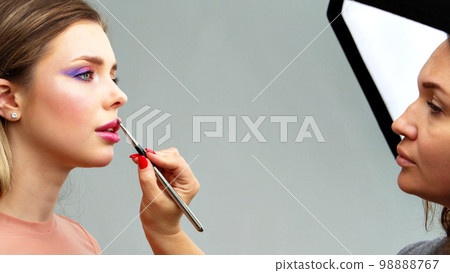 Backstage of the photo shoot: Make-up artist applies makeup on beautiful white  model. Tutorial makeup master class. 98888767