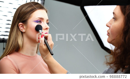 Backstage of the photo shoot: Make-up artist applies makeup on beautiful white model. Tutorial makeup master class. Backstage of the photo shoot: Make-up artist applies makeup on beautiful white model. Tutorial makeup master class. 98888772