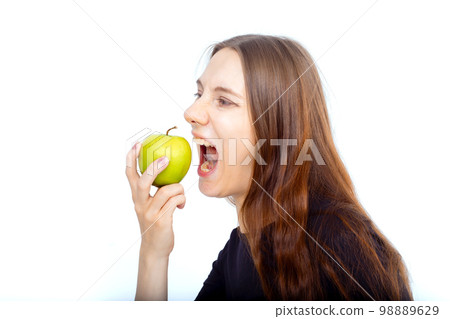Pregnant woman propose apple for her belly copy space. Beautiful expectant lady having fresh snack, gray studio background. Healthy nutrition and pregnancy concept, copy space 98889629