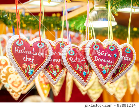 Several Austrian heart-shaped Christmas gingerbread hanging in a display case 98891214