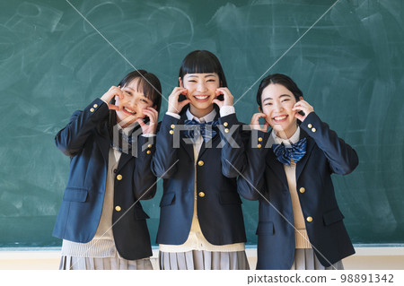 高中女生和她的朋友在教室的黑板前合影 98891342