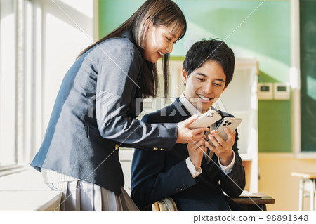 在學校教室裡使用智能手機的男女高中生 98891348