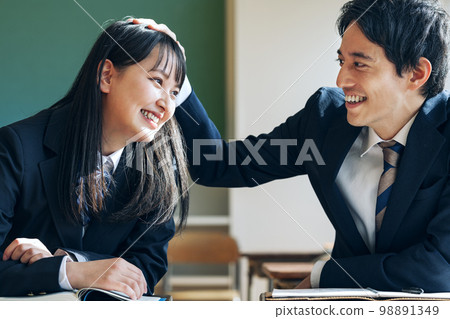 Male and female students getting along in a school classroom 98891349