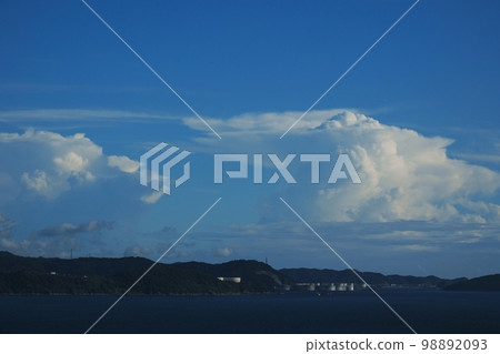 Afternoon coastal landscape with industrial complex harbor and various clouds in the distance Summer 220727pm 98892093