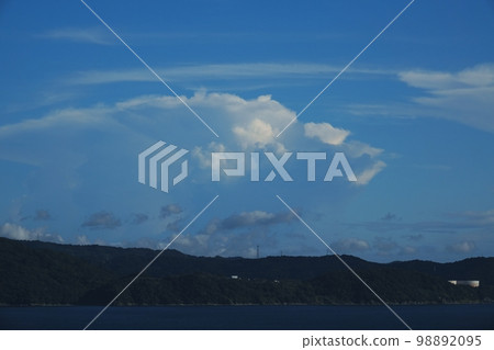 Afternoon coastal landscape with industrial complex harbor and various clouds in the distance Summer 220727pm Afternoon coastal landscape with industrial complex harbor and various clouds in the distance Summer 220727pm 98892095