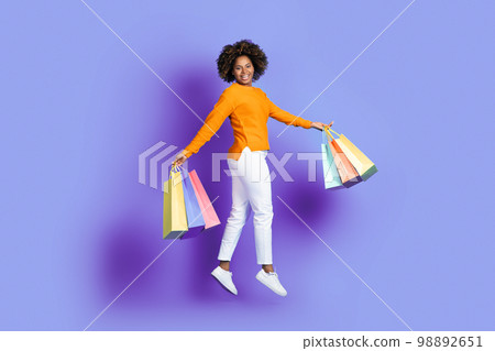 Emotional young african american woman jumping with shopping bags 98892651