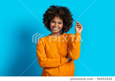 Playful young black woman posing on blue studio background 98892698