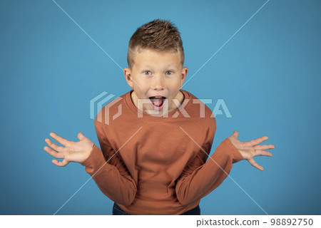 Wow. Portrait Of Exited Boy Opening Mouth And Spreading Hands In Amazement Wow. Portrait Of Exited Boy Opening Mouth And Spreading Hands In Amazement 98892750