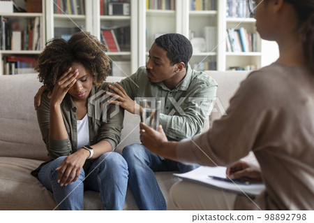Loving black man comforting crying wife while having family therapy Loving black man comforting crying wife while having family therapy 98892798
