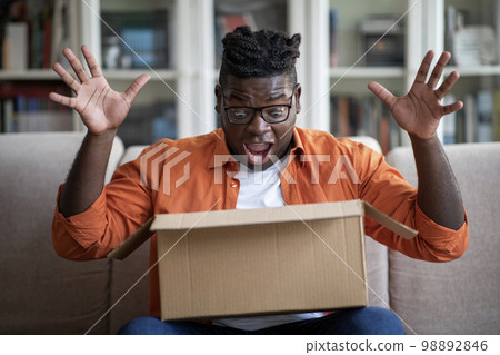 Excited fat african man customer receive good parcel, opening delivery 98892846