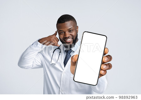 Cheerful Black Male Doctor Showing Big Blank Smartphone And Gesturing Call Me 98892963
