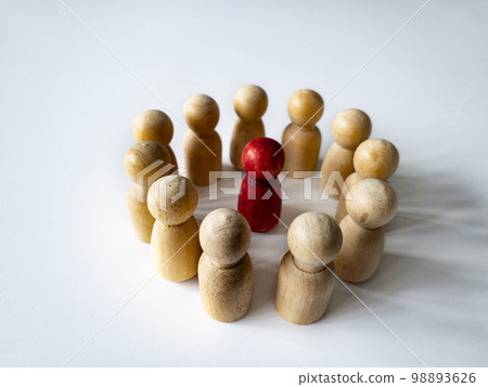 Red wooden doll figure surrounded by other doll figure on white background. Harassment and bully concept. 98893626