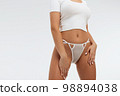 Faceless gorgeous woman with hands on thighs posing in studio 98894038