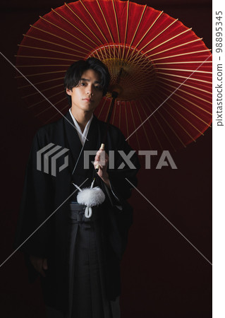 A man in a hakama with a crest, a Japanese umbrella 98895345