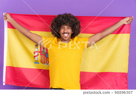 Happy african man raising a spanish flag 98896307