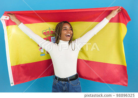 Smiling african woman waving a spanish national flag Smiling african woman waving a spanish national flag 98896325
