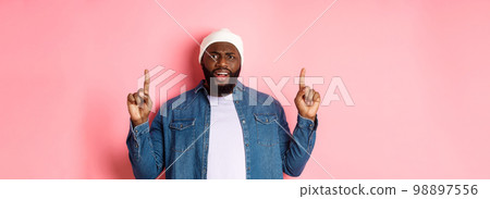Disappointed and upset Black man frowning, pointing fingers up and staring at camera bothered, complaining at something, standing over pink background Disappointed and upset Black man frowning, pointing fingers up and staring at camera bothered, complaining at something, standing over pink background 98897556