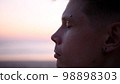 Thoughtful guy on the beach during sunset 98898303