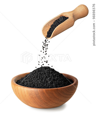 black cumin seeds pouring out from wooden scoop in bowl isolated on white black cumin seeds pouring out from wooden scoop in bowl isolated on white 98898376