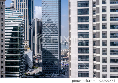 modern building. Reflective skyscrapers, business office buildings. Facade of modern office building. Doha business district. Business, economy and finances concept. 98899271
