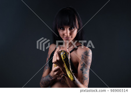 Photo of brunette woman with anaconda in shadows 98900314