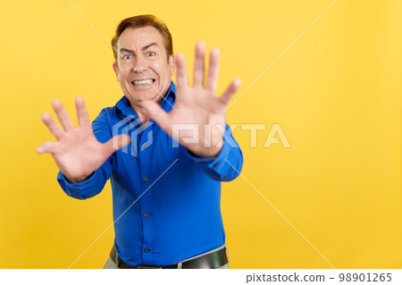 Mature man gesturing with the hands in fear 98901265
