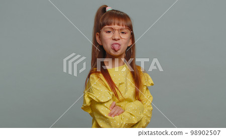 Cheerful funny bully child girl showing tongue making silly faces, fooling around, joking, teasing Cheerful funny bully child girl showing tongue making silly faces, fooling around, joking, teasing 98902507