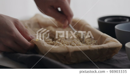 man making granola at home, mix flakes with honey man making granola at home, mix flakes with honey 98903335