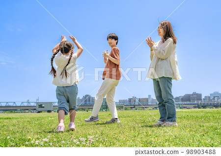 Smiling good family practicing dance in the park 98903488