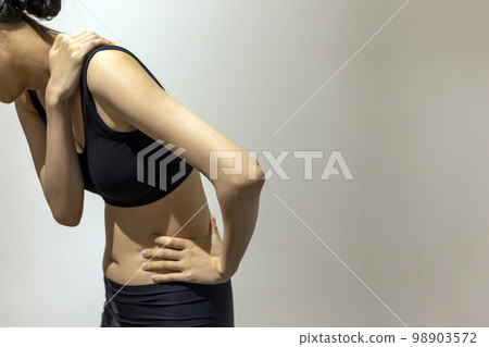 一個女人穿著黑色運動服站在她的肩膀和側面的側視圖 一個女人穿著黑色運動服站在她的肩膀和側面的側視圖 98903572