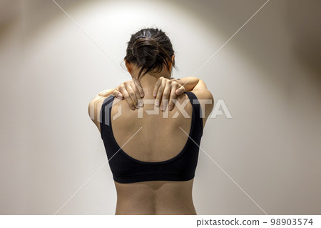 一位身穿黑色運動服、雙手遮住肩膀的女性的後視圖 98903574